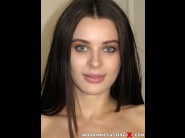 Lana rhoades is sited on a sofa, legs appart and looking at you